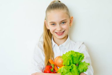 İzole sebze tutan mutlu fitness kız