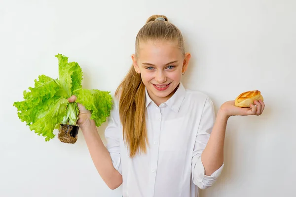 Junges Mädchen hat die Wahl zwischen Salat und Backen — Stockfoto