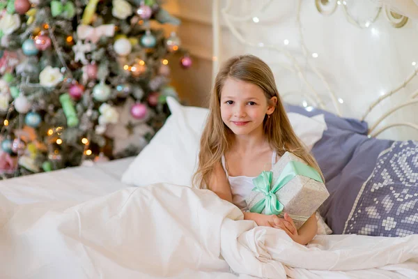 Mädchen wacht am Weihnachtsmorgen in ihrem Bett auf — Stockfoto