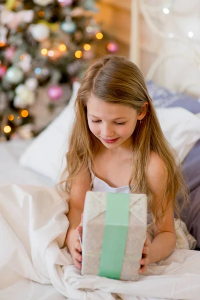 Niña despierta en su cama en la mañana de Navidad — Foto de Stock