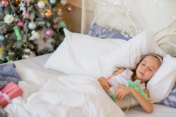 Niña durmiendo en su cama en la mañana de Navidad — Foto de Stock
