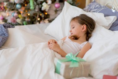 Kız çocuk Noel sabah yatağında uyumak
