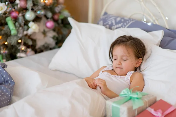 Дитяча дівчина прокидається в ліжку в Різдвяний ранок — стокове фото