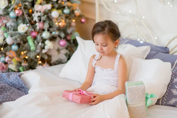 Niña despierta en su cama en la mañana de Navidad — Foto de Stock