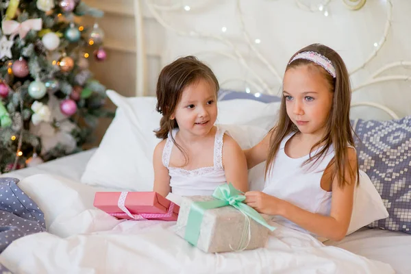 Mädchen wachen am Weihnachtsmorgen im Bett auf — Stockfoto