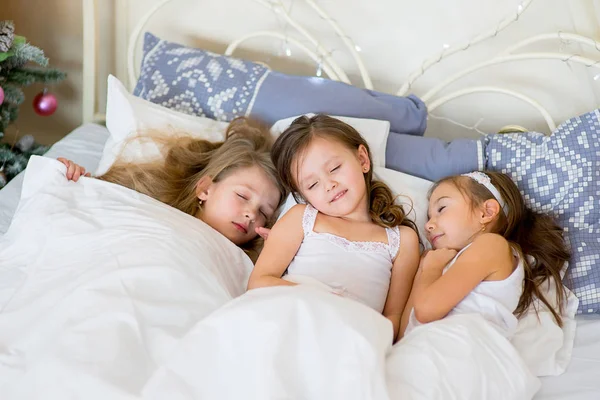 Niñas duermen en su cama en la mañana de Navidad — Foto de Stock