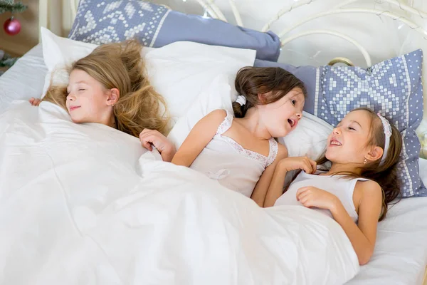 Niñas duermen en su cama en la mañana de Navidad — Foto de Stock