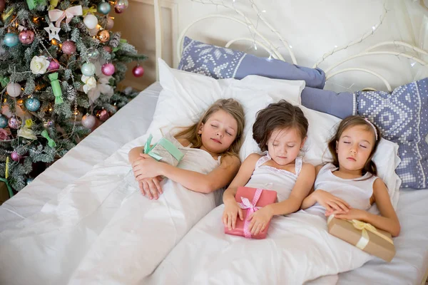 Niñas duermen en su cama en la mañana de Navidad — Foto de Stock