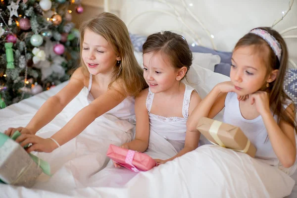 Niñas se despiertan en su cama en la mañana de Navidad — Foto de Stock