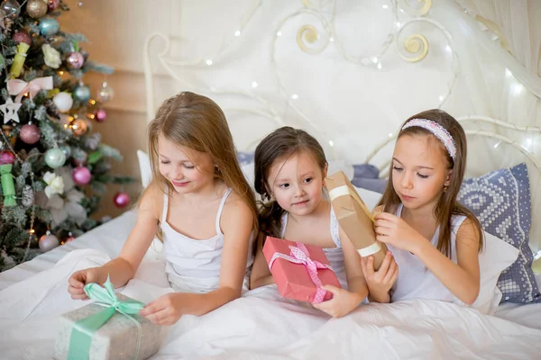 Дитячі дівчата прокидаються в ліжку в різдвяний ранок — стокове фото