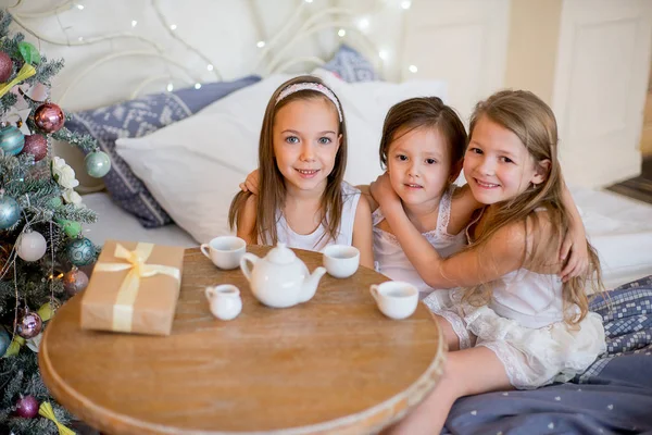 Дитячі дівчата прокидаються в ліжку в Різдвяний ранок — стокове фото