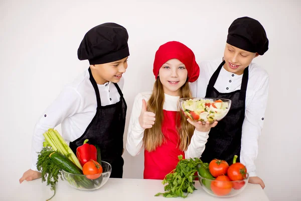 Tres jóvenes chefs evalúan una ensalada aislada — Foto de Stock