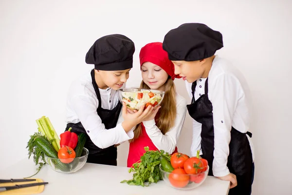 Trzech młodych kucharzy oceny Sałatka na białym tle — Zdjęcie stockowe