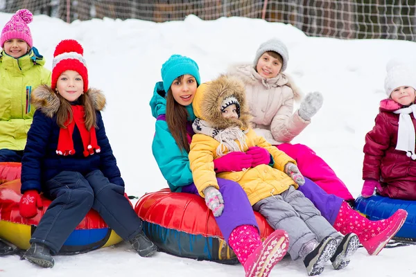 Barnen på snö rör neråt på vinterdag — Stockfoto