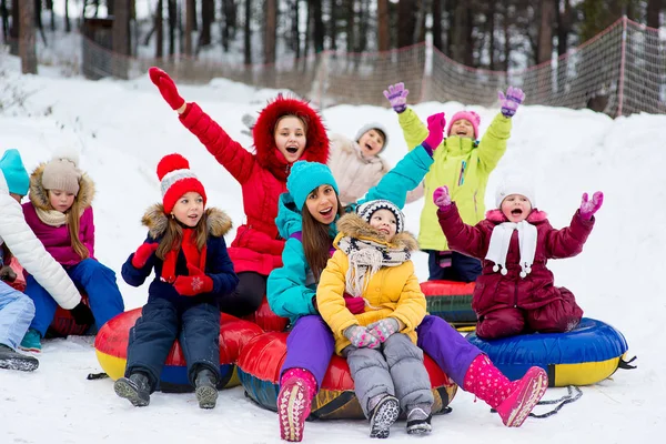 Діти на снігових трубках спускаються в зимовий день — стокове фото
