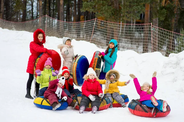 孩子们对雪管下坡在冬季的一天 — 图库照片