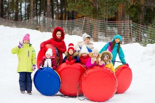 Dzieci na śnieg rury zjazdowe w zimowy dzień — Zdjęcie stockowe