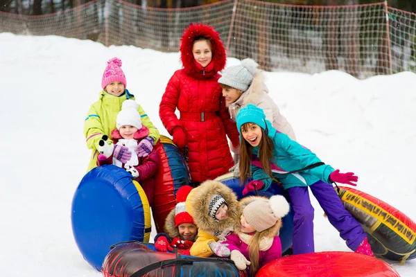 Enfants sur des tubes à neige en descente le jour d'hiver — Photo