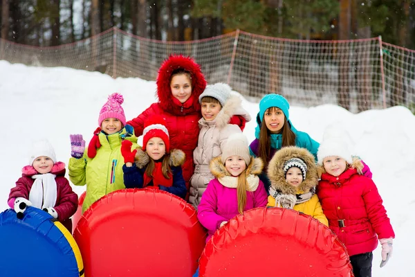 Enfants sur des tubes à neige en descente le jour d'hiver — Photo