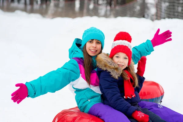 Bambini sui tubi di neve in discesa durante la giornata invernale — Foto Stock