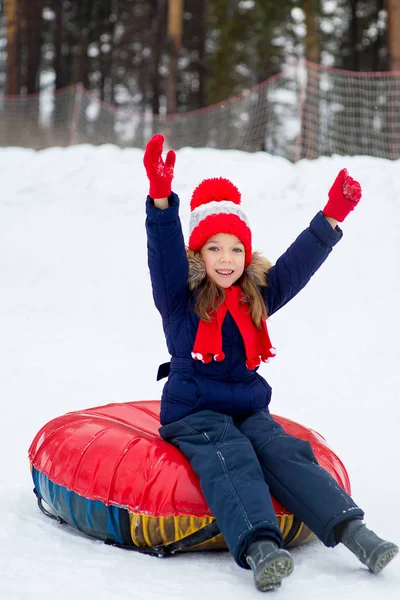 Liten flicka på snö rör störtlopp på vinterdag — Stockfoto