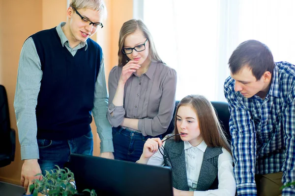 Four employees looking at laptop — Stock Photo, Image
