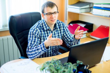 laptop önünde oturan işçi