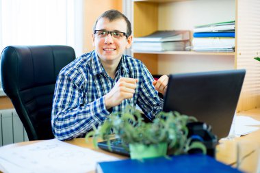 laptop önünde oturan işçi