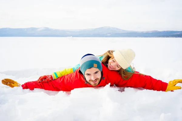 Glückliches Paar liegt im Schnee — Stockfoto