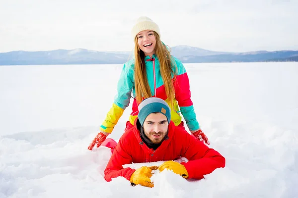 Glückliches Paar liegt im Schnee — Stockfoto