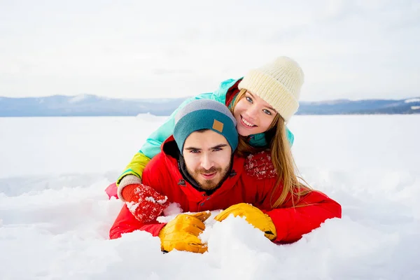 Glückliches Paar liegt im Schnee — Stockfoto