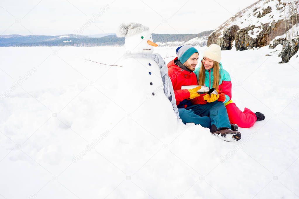 Couple drinking tea outdoors in winter