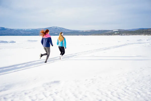 Two girls jogging in winter — Stock Photo, Image