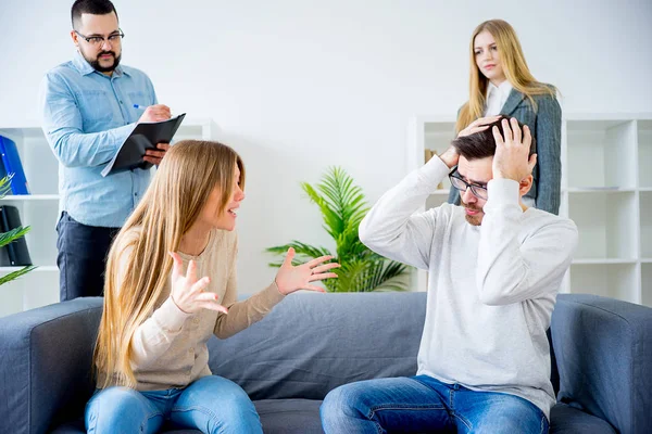 Pareja discutiendo en sesión de terapia en consultorio de terapeutas — Foto de Stock