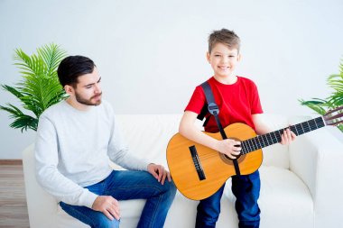 Baba oğul gitar çalıyor.