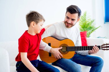 Baba oğul gitar çalıyor.