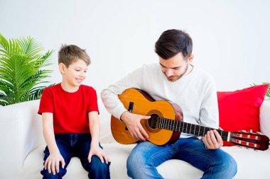 Baba oğul gitar çalıyor.