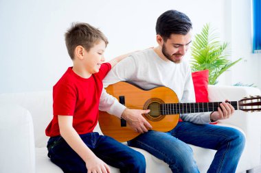 Baba oğul gitar çalıyor.