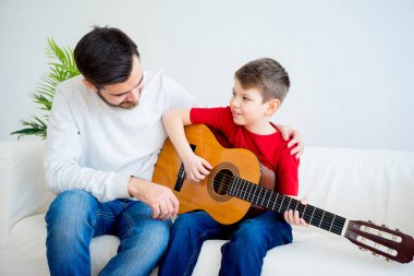 Baba oğul gitar çalıyor.