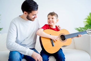 Baba oğul gitar çalıyor.