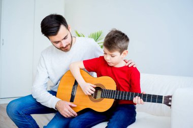 Baba oğul gitar çalıyor.