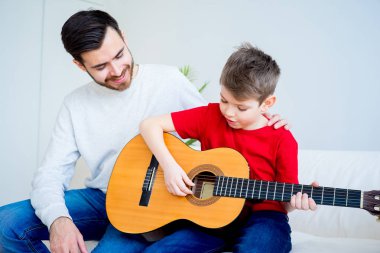 Baba oğul gitar çalıyor.