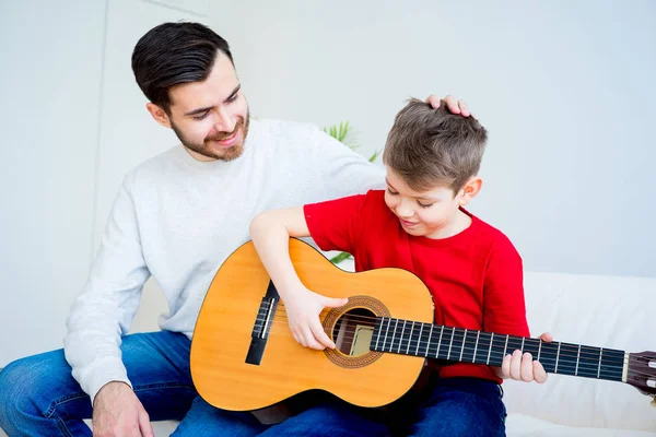 Baba oğul gitar çalıyor.