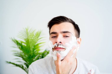 Adam sakalını kesiyor.