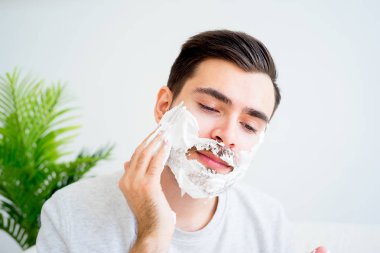 Adam sakalını kesiyor.