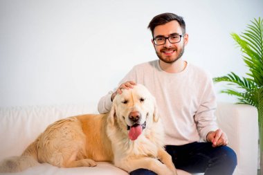 Adam köpeğiyle oynuyor.