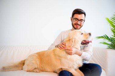 Adam köpeğiyle oynuyor.