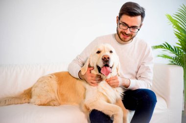 Adam köpeğiyle oynuyor.