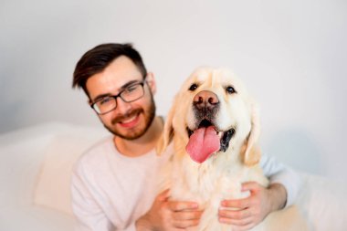 Adam köpeğiyle oynuyor.