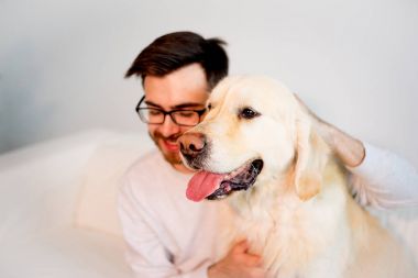 Adam köpeğiyle oynuyor.